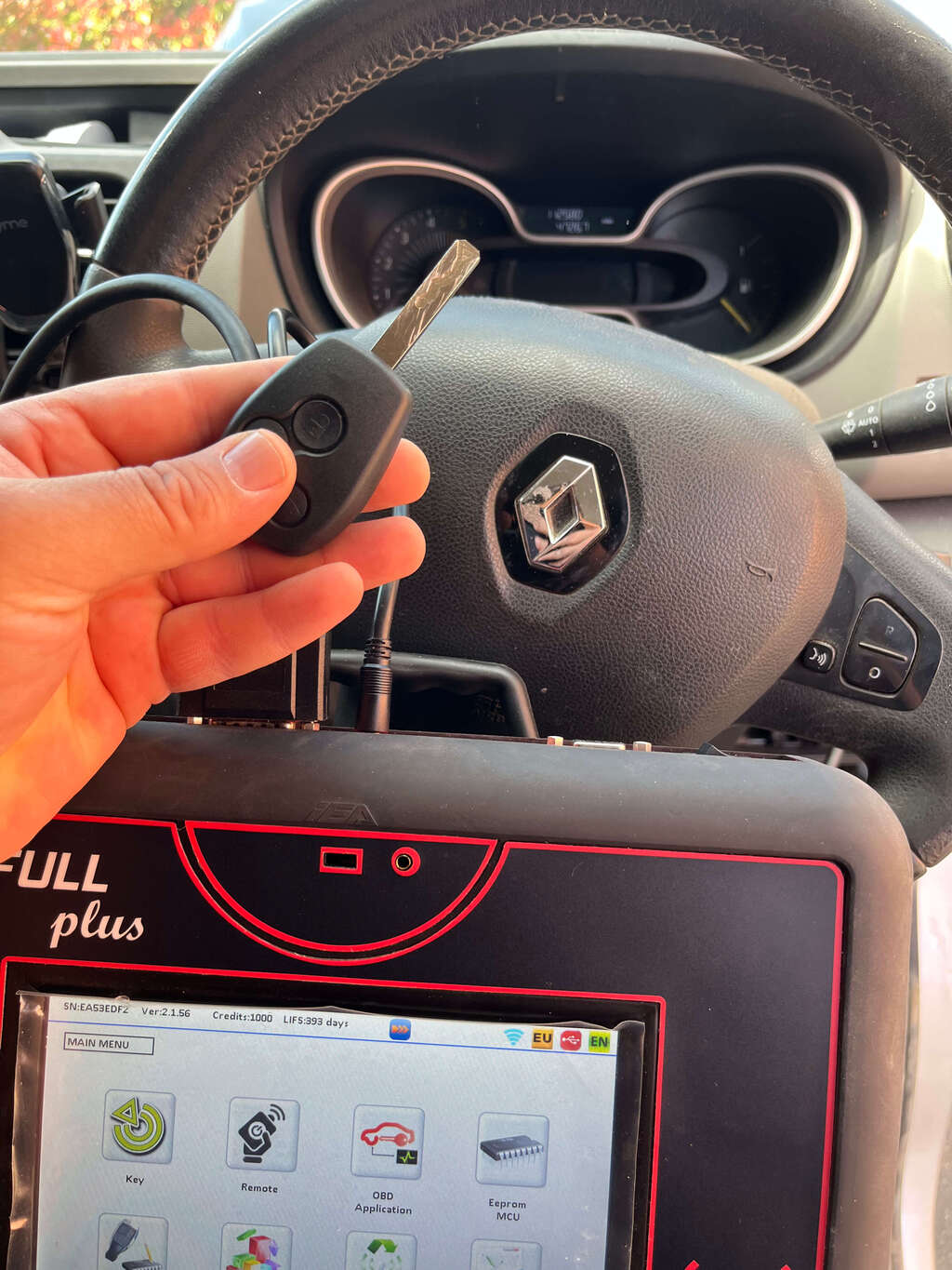 Mobile auto locksmith in Evesham programming a Renault key using diagnostic equipment inside the vehicle.