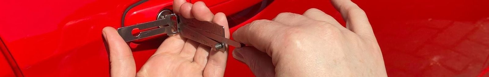 Technician using air wedge and long reach tool for non-destructive vehicle entry