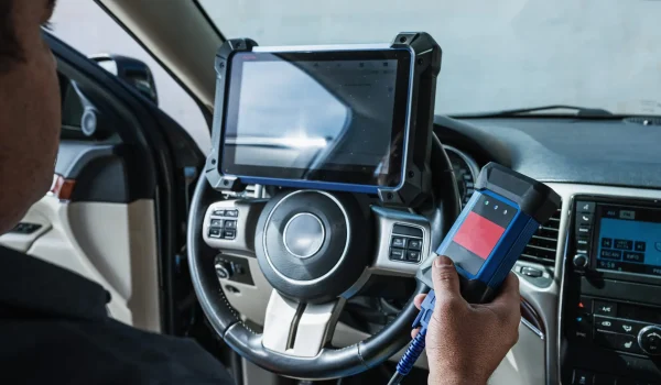 Car diagnostic. Technical inspection, car electronics. A Latin man holds a digitizing device.
